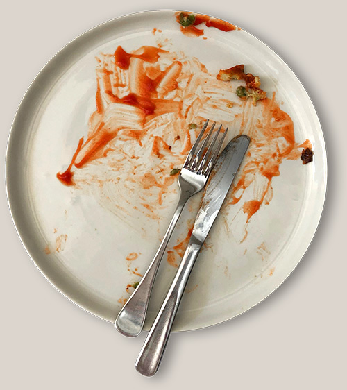 A plate with the aftermath of a delicious ketchup-y dinner.